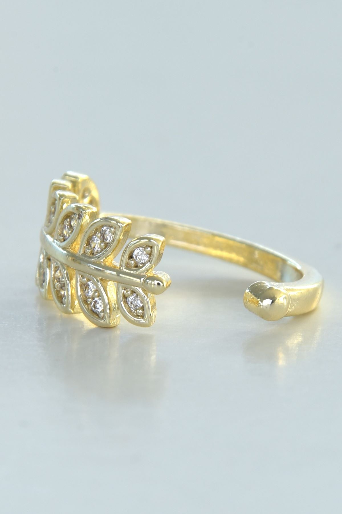 Flourish-ring i gullfarget stål med bladerdesign og glitrende steiner