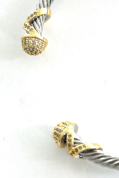 Cho armbånd i tofarget design med teksturert metall i sølv- og gullfarge, 6.5 cm diameter.